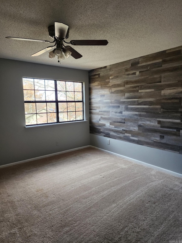 carpeted empty room featuring a textured ceiling and ceiling fan