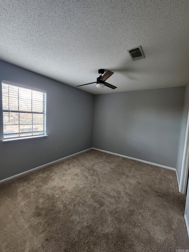 carpeted spare room with ceiling fan and a textured ceiling