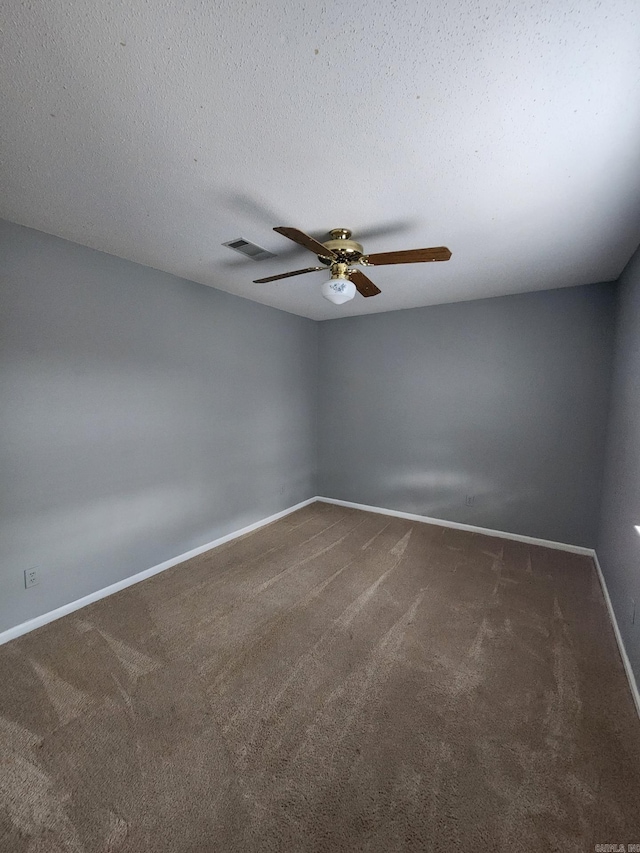 unfurnished room featuring dark carpet, a textured ceiling, and ceiling fan