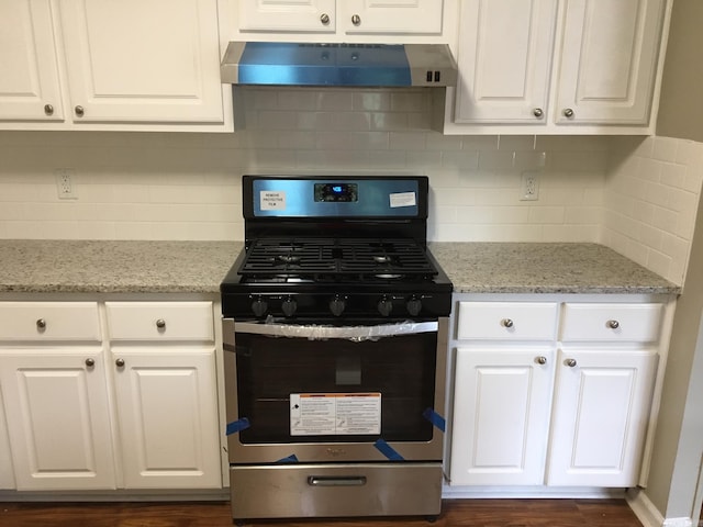 kitchen featuring light stone counters, white cabinetry, backsplash, and stainless steel gas range oven