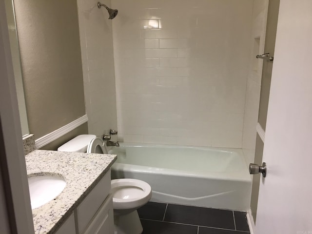 full bathroom with tile patterned flooring, tiled shower / bath combo, vanity, and toilet