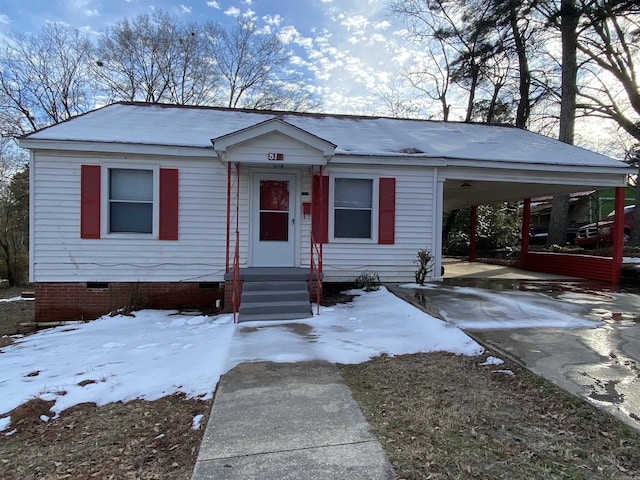 view of front of house with driveway, an attached carport, and crawl space