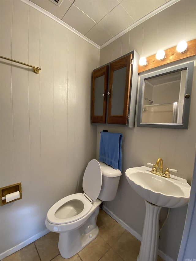 bathroom with toilet, tile patterned floors, and crown molding