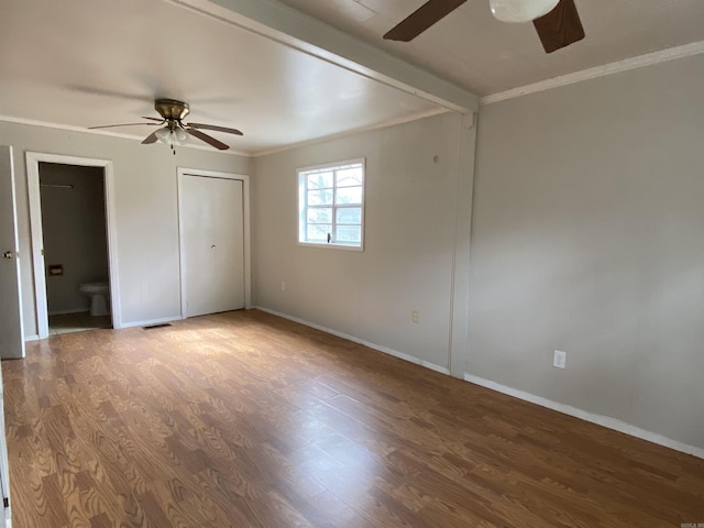 unfurnished bedroom featuring visible vents, crown molding, baseboards, and wood finished floors