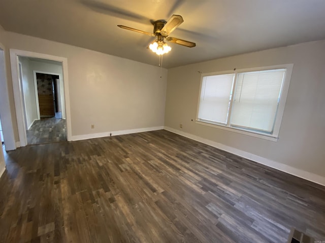 empty room with a ceiling fan, dark wood-style flooring, and baseboards