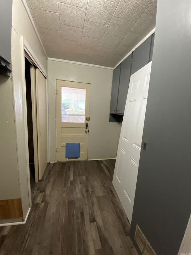 doorway featuring crown molding and dark hardwood / wood-style floors