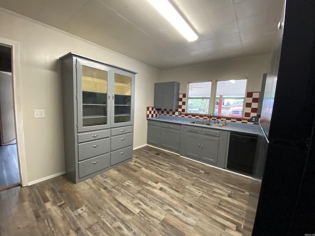 kitchen featuring sink, backsplash, dark hardwood / wood-style floors, black appliances, and gray cabinetry