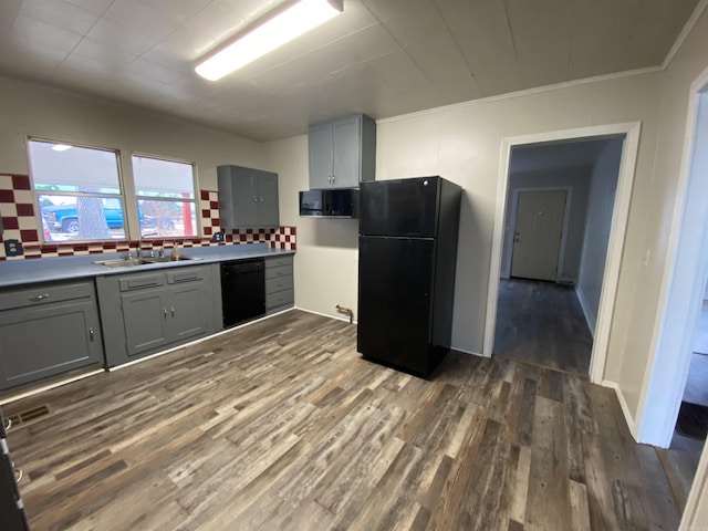 kitchen with sink, gray cabinets, decorative backsplash, dark hardwood / wood-style floors, and black appliances