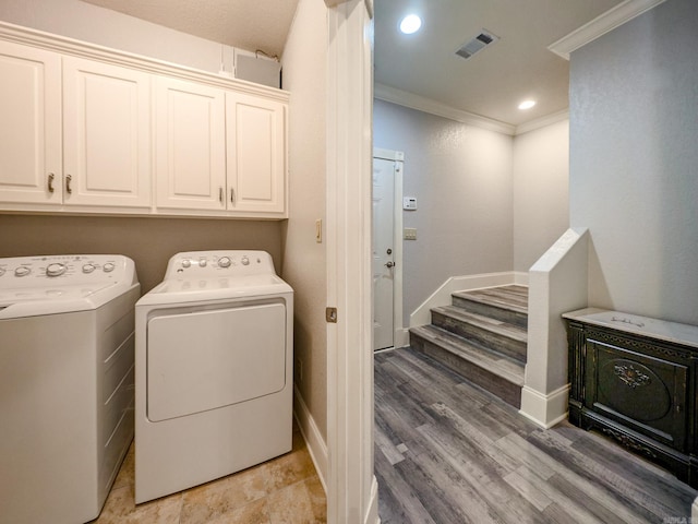 washroom with ornamental molding, separate washer and dryer, and light hardwood / wood-style flooring