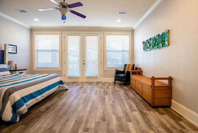 bedroom featuring ceiling fan, multiple windows, hardwood / wood-style floors, and crown molding