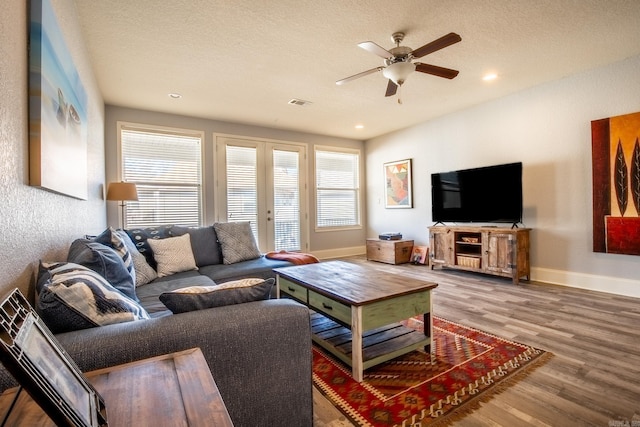 living room featuring a textured ceiling, ceiling fan, and hardwood / wood-style flooring