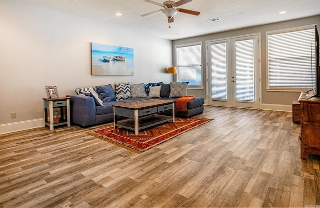 living room with french doors, a textured ceiling, ceiling fan, and light hardwood / wood-style flooring