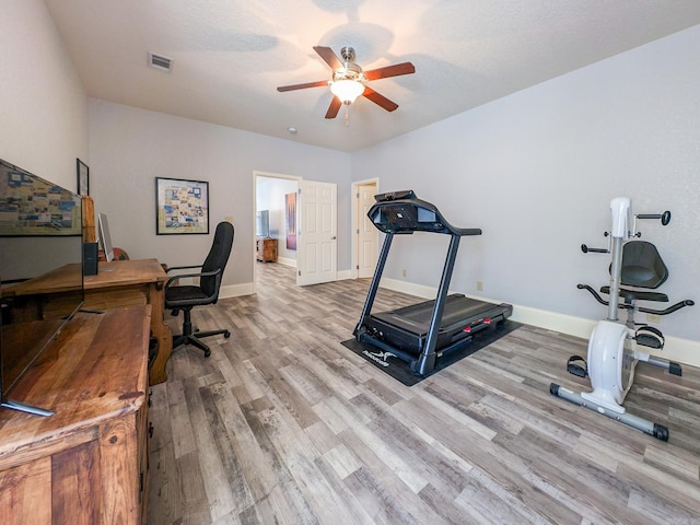 workout area featuring ceiling fan and light wood-type flooring