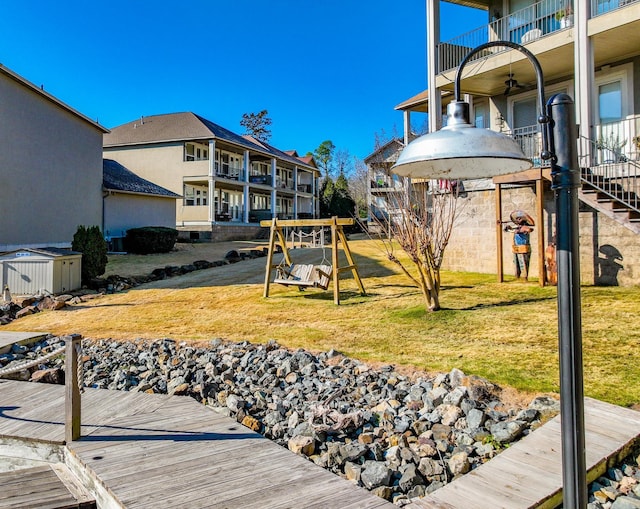 view of yard featuring ceiling fan, a balcony, and a playground