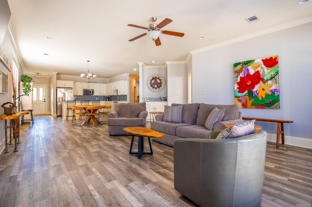 living room featuring crown molding, ceiling fan with notable chandelier, and hardwood / wood-style flooring