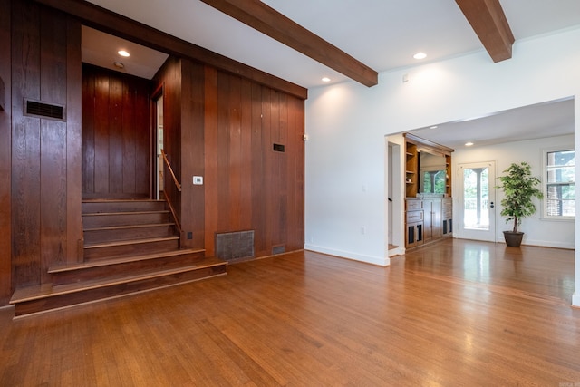 interior space with wood-type flooring, wooden walls, and beamed ceiling