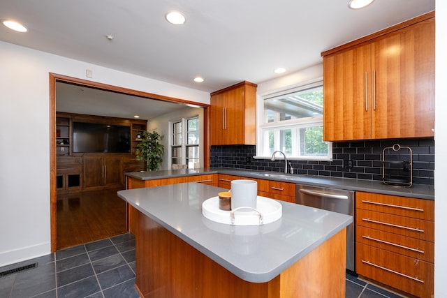 kitchen with sink, dark tile patterned floors, and a center island