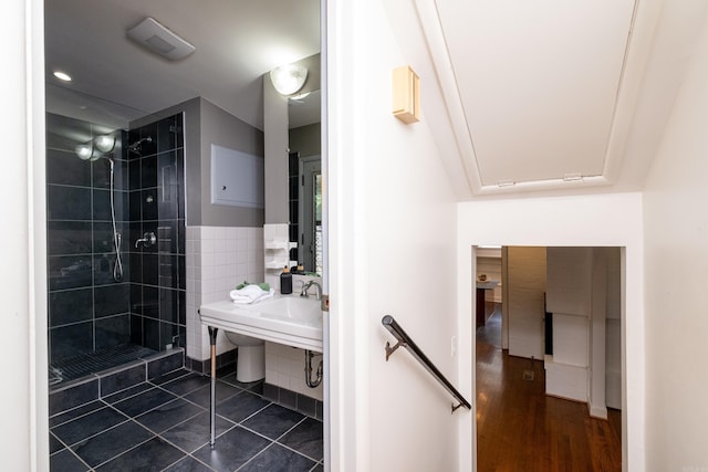 bathroom with a tile shower, tile patterned flooring, and sink