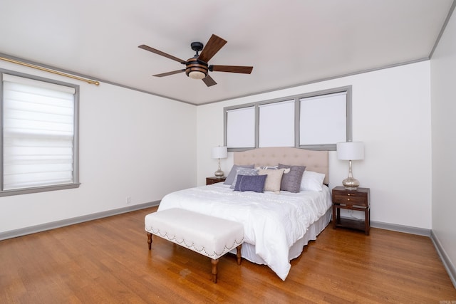 bedroom featuring ceiling fan, crown molding, and hardwood / wood-style flooring