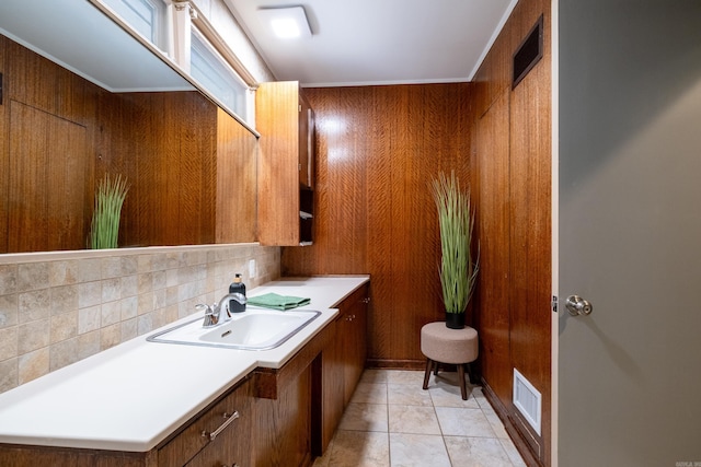 bathroom featuring wood walls, crown molding, vanity, tile patterned floors, and decorative backsplash