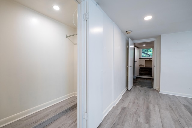 corridor with light hardwood / wood-style floors