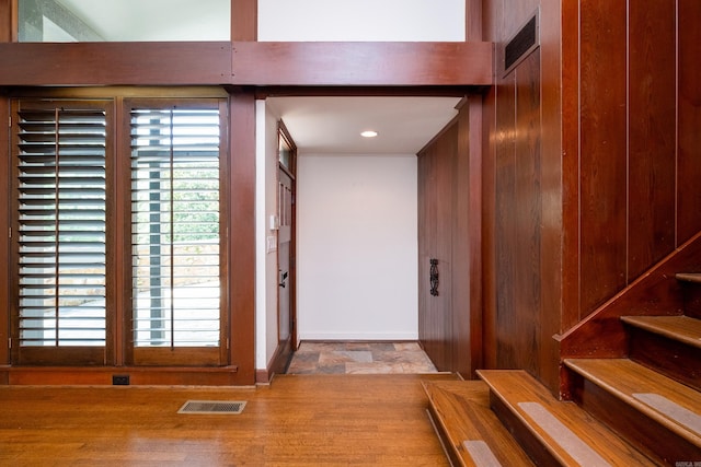 hallway featuring wood walls