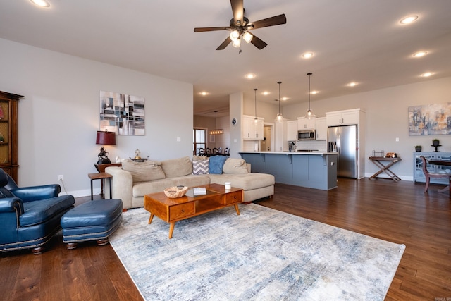 living room with ceiling fan and dark hardwood / wood-style flooring