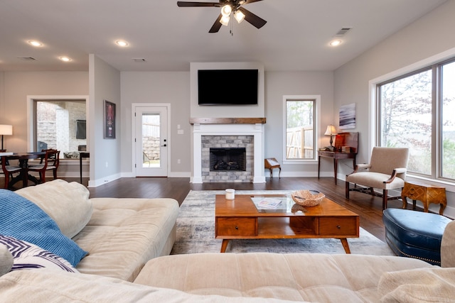 living room featuring a fireplace, wood-type flooring, ceiling fan, and a wealth of natural light