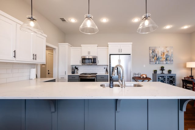 kitchen with sink, white cabinetry, decorative backsplash, hanging light fixtures, and appliances with stainless steel finishes