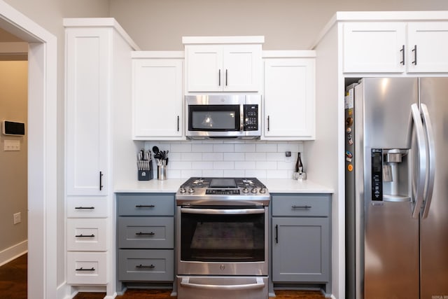 kitchen featuring stainless steel appliances, decorative backsplash, white cabinetry, and gray cabinets