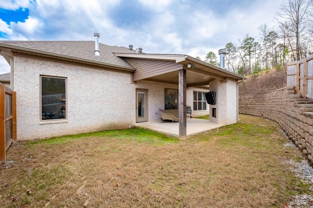 rear view of property featuring a lawn and a patio