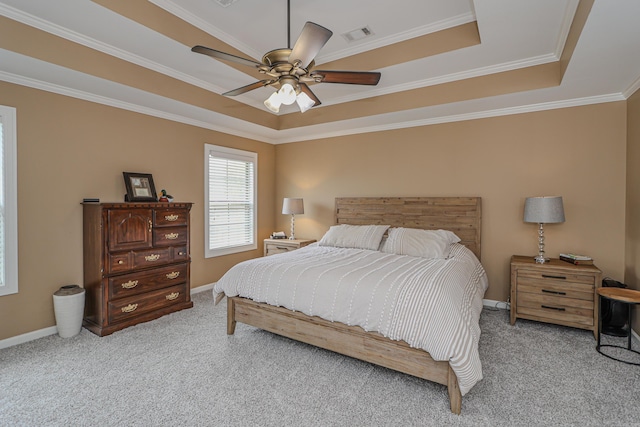 bedroom featuring ceiling fan, ornamental molding, and a tray ceiling