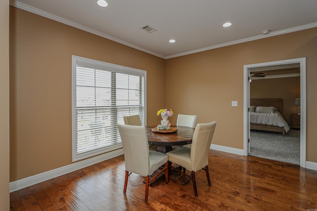 dining space featuring hardwood / wood-style floors and crown molding