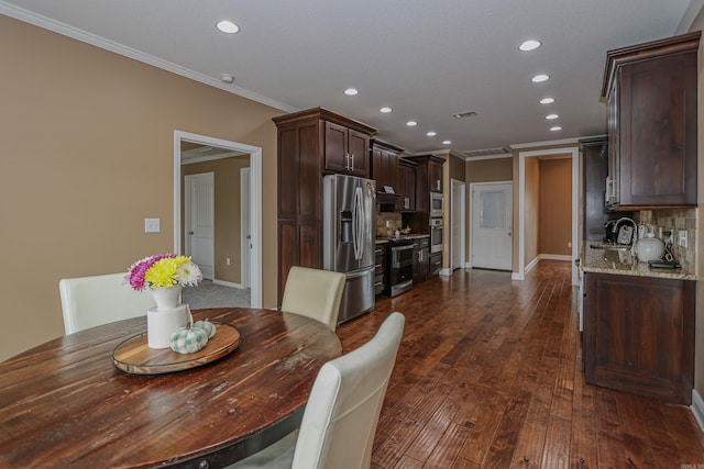 dining area featuring sink, crown molding, and dark hardwood / wood-style floors