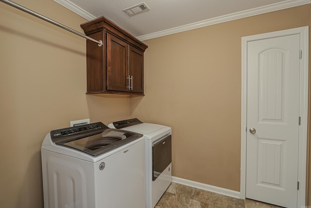 washroom featuring washing machine and clothes dryer, ornamental molding, and cabinets