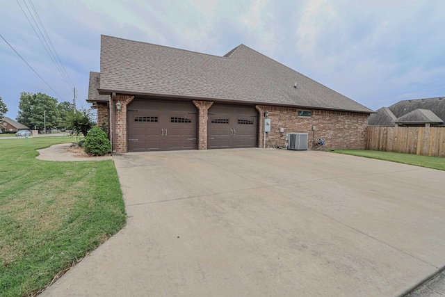 view of property exterior with a yard, central AC unit, and a garage