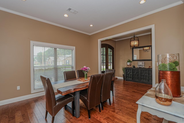 dining area with crown molding and hardwood / wood-style floors