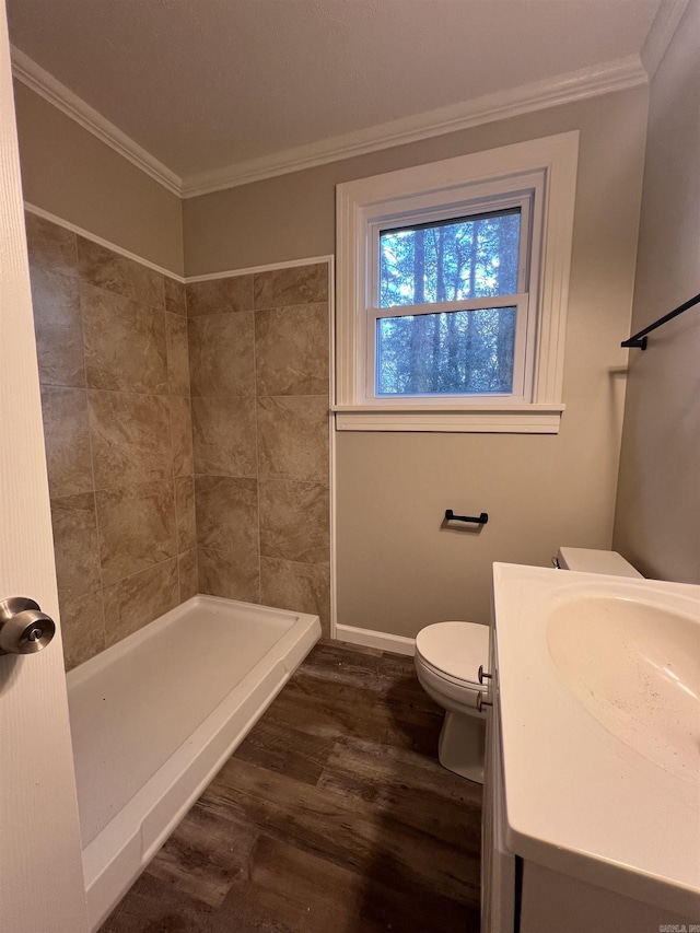 bathroom with toilet, a shower, crown molding, wood-type flooring, and vanity