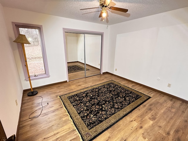 interior space with ceiling fan, hardwood / wood-style flooring, and a textured ceiling