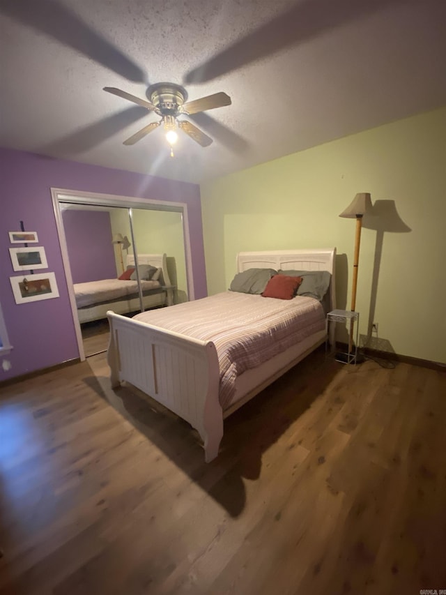 bedroom with a closet, a textured ceiling, ceiling fan, and wood-type flooring