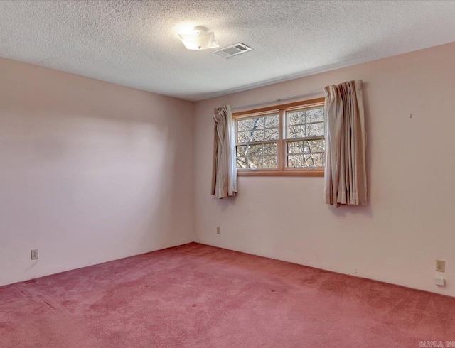 carpeted empty room with a textured ceiling