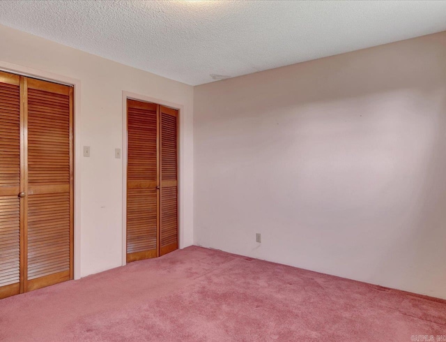 unfurnished bedroom featuring a textured ceiling and carpet