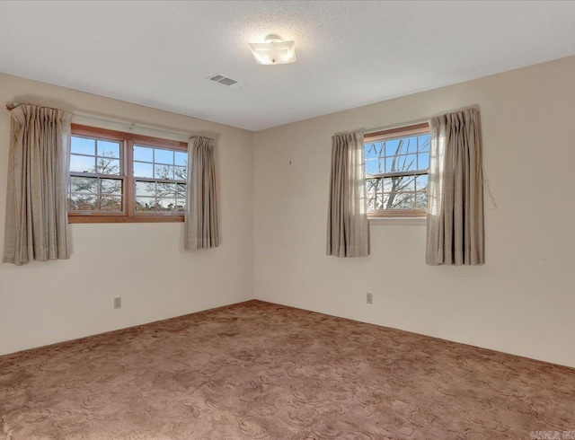 empty room with a textured ceiling and carpet