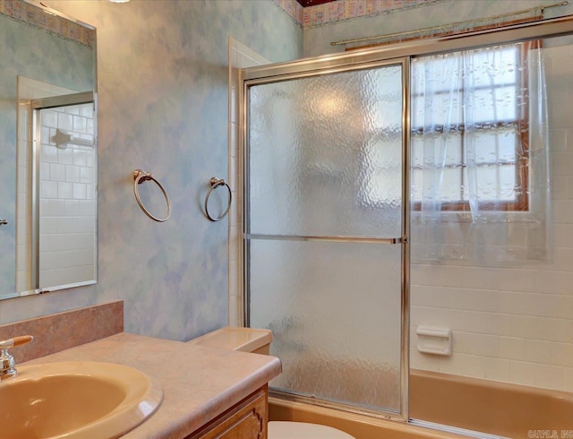 full bathroom with enclosed tub / shower combo, vanity, and toilet