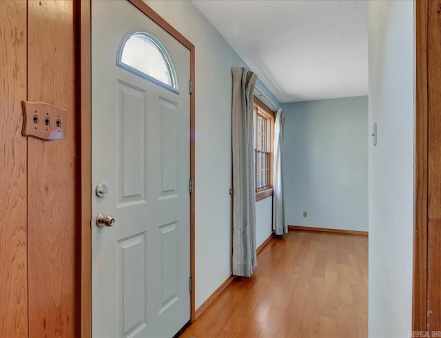 entrance foyer with a textured ceiling and light hardwood / wood-style floors