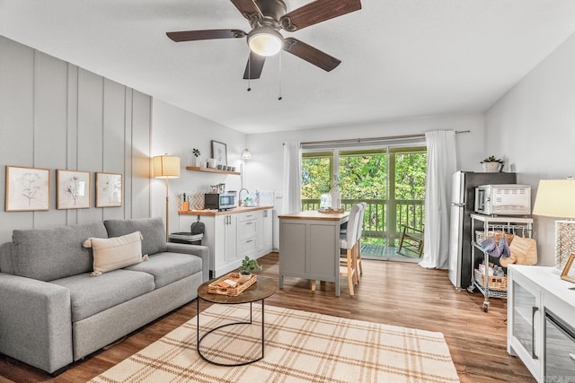 living room with sink, hardwood / wood-style floors, and ceiling fan