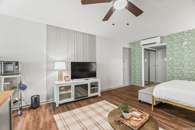 bedroom featuring ceiling fan, hardwood / wood-style floors, and an AC wall unit