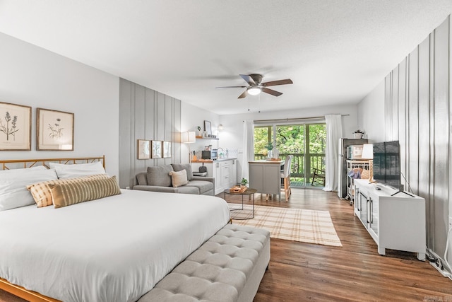 bedroom featuring access to exterior, ceiling fan, a textured ceiling, and dark hardwood / wood-style floors