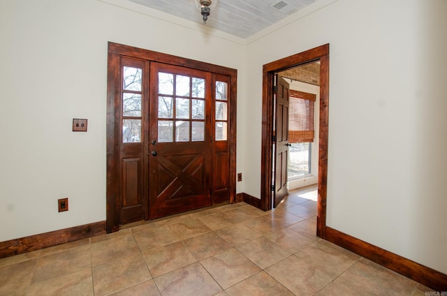 tiled entrance foyer featuring ornamental molding and plenty of natural light