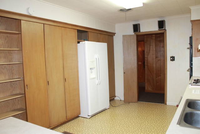 kitchen featuring white fridge with ice dispenser and sink